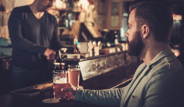 stylish-man-sitting-alone-at-bar-counter-with-a-pi-2024-10-12-18-37-55-utc-2
